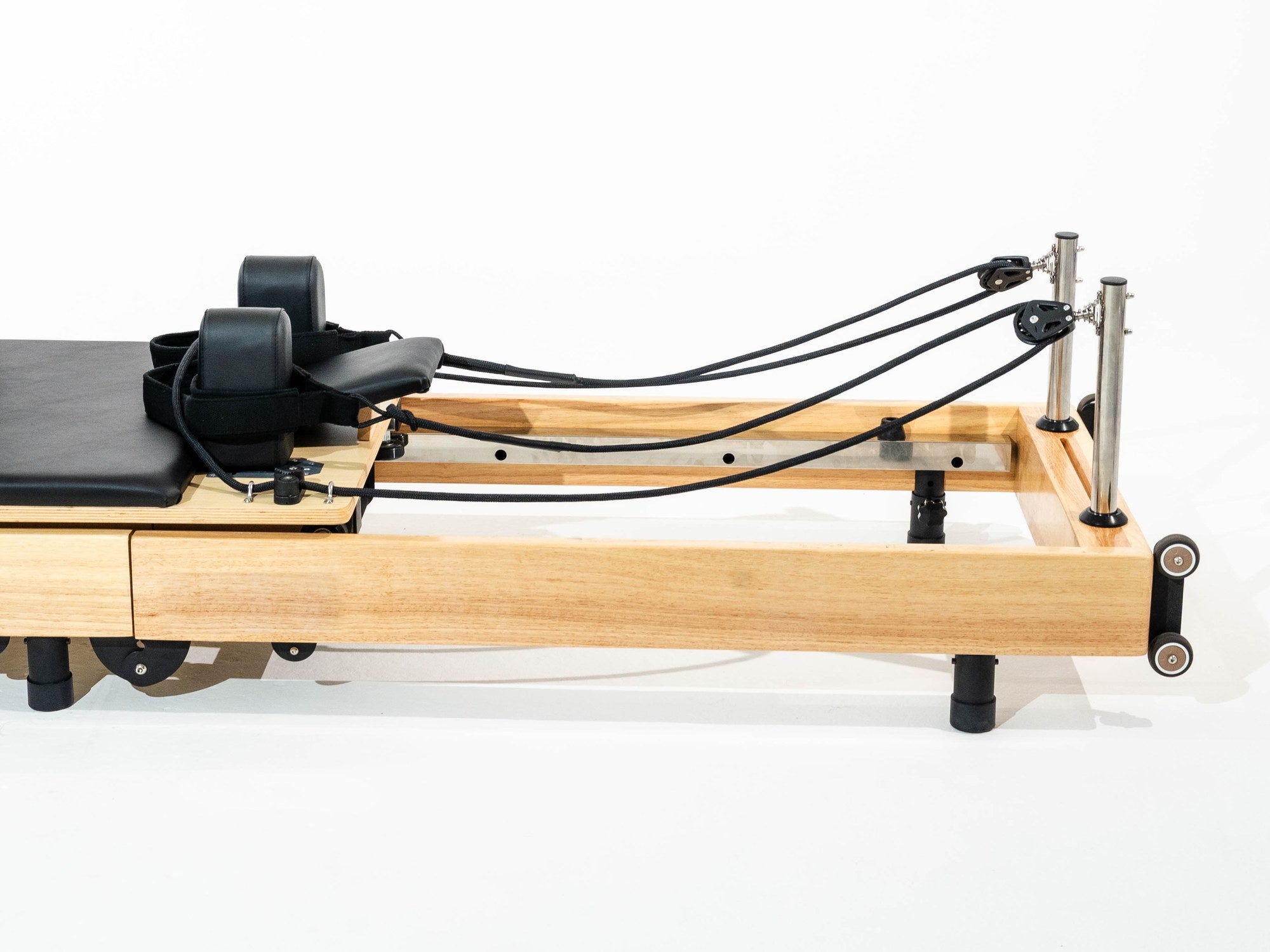 The solid wood frame and rails of the Seren reformer, seen from the side
