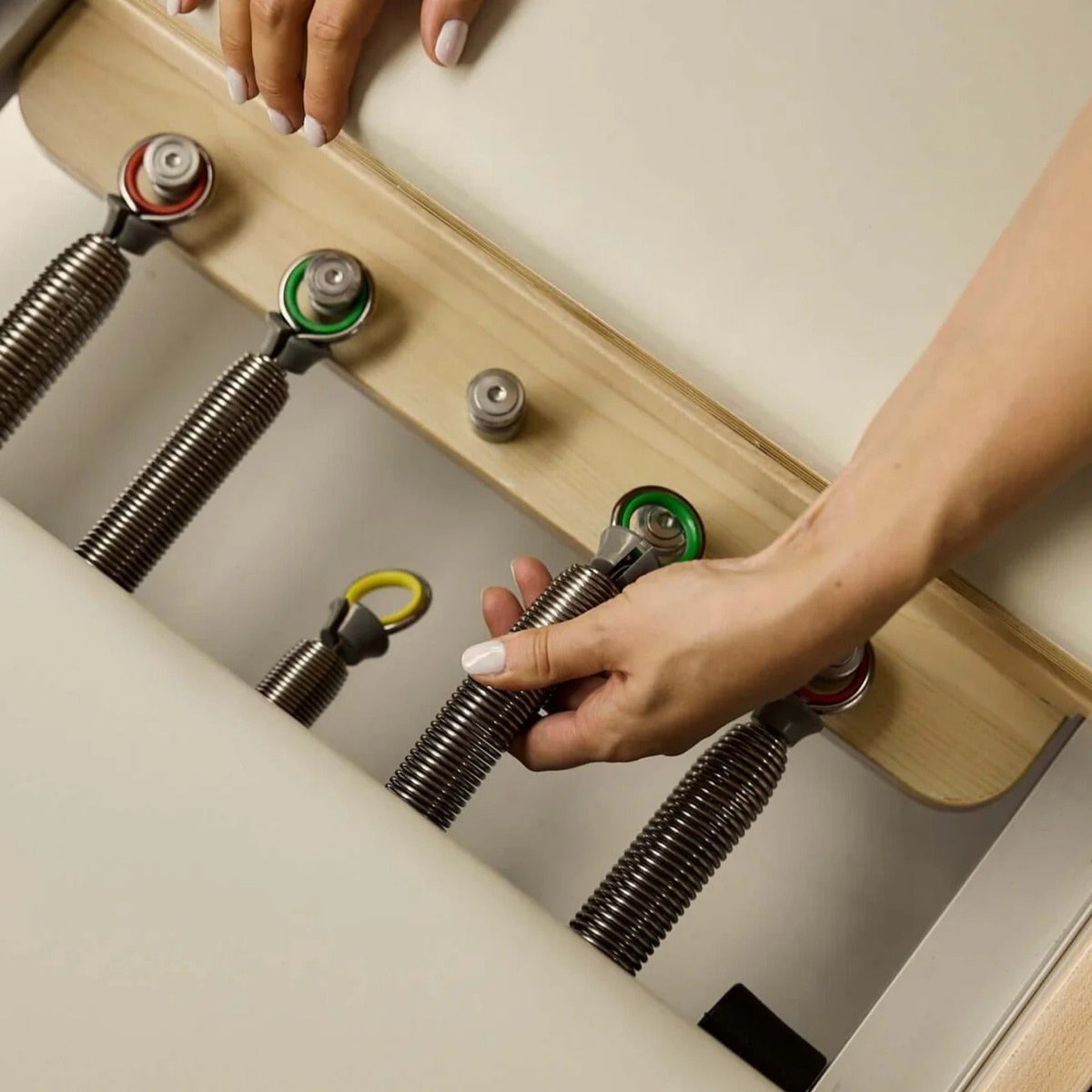 Hands changing a spring on the colour-coded spring bar